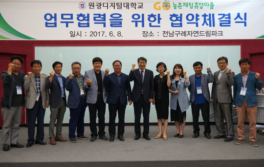 남궁문 원광디지털대 총장(왼쪽 일곱번째)과 이규정 전국농촌체▼험휴양마을협의회장(여섯번째)이 농촌관광 활성화를 위한 업무협약을 체결하고 양측 관계자들과 기념촬영을 하고 있다.   원광디지털대 제공